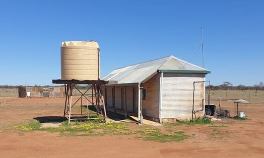 Poly water tank on a tank stand outdoors