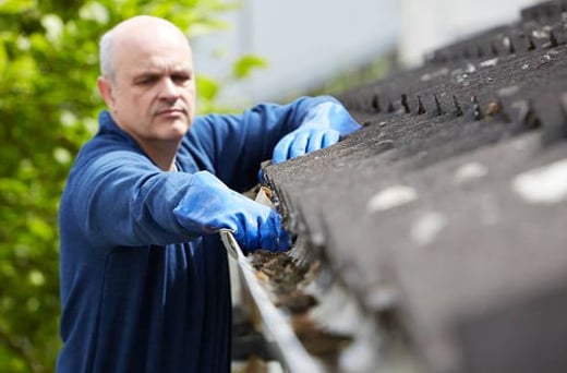 man cleaning gutters